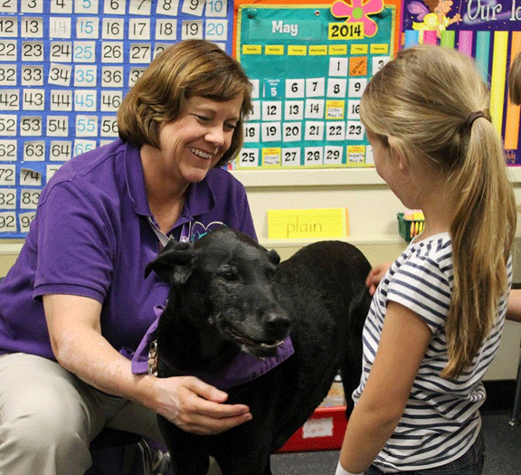 Teacher and student with a dog in classroom